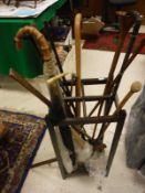 A stick stand and quantity of assorted sticks, umbrella with yellow metal collar, hunting horn,