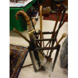 A stick stand and quantity of assorted sticks, umbrella with yellow metal collar, hunting horn,