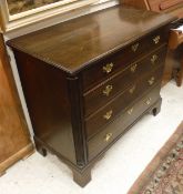 An oak chest in the George III manner of four long graduated drawers flanked by fluted quarter cut