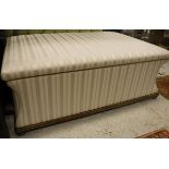 A waisted rectangular box ottoman in cream striped upholstery and beech frame