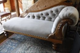 A mid Victorian oak framed chaise longue on turned supports to brass caps and castors