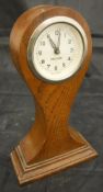 An oak cased balloon clock of small proportions,