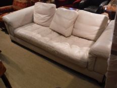 A cream leather upholstered three seat sofa