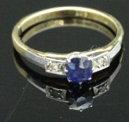 An 18 carat gold dress ring set with central sapphire and two chip diamonds, total approx 2.