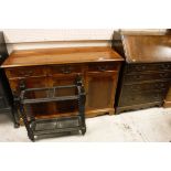 A 20th Century yew sideboard of three drawers above three cupboard doors with a shaped apron,
