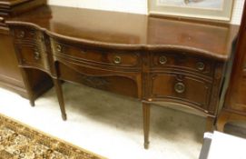 An Edwardian mahogany serpentine fronted sideboard in the Chippendale revival taste with two