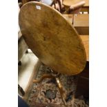 A 19th Century oak tilt-top circular tea table with baluster turned support,