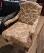 A Victorian walnut framed upholstered open arm chair on turned front legs to castors