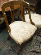 A set of six walnut framed dining chairs with cream and patterned upholstered seats,