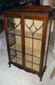 A mahogany display cabinet with two astragal glazed doors enclosing shelves,