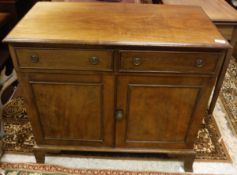 A circa 1900 mahogany side cabinet with two drawers over a single cupboard door on bracket feet