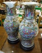 A pair of 19th Century Cantonese famille-rose vases decorated with various figures in interiors,