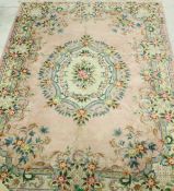 A Chinese rug, the central panel set with a floral decorated medallion on a cream and pink ground,