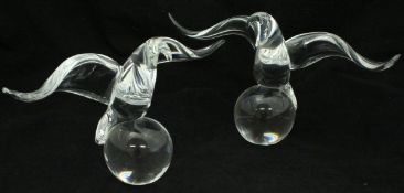 A pair of Steuben clear glass paperweights as eagles on balls,