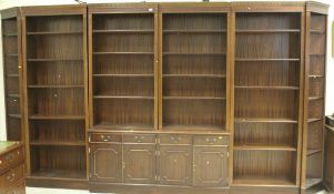 A large reproduction mahogany bookcase cabinet consisting of two central sections of shelves above