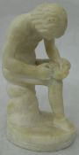 A 19th Century alabaster figure of a nude picking a thorn from his foot