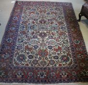 A Kashan rug, the central panel set with all over floral decoration on a cream ground,