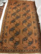 An Afghan rug, the central panel set with repeating medallions on an oxblood red ground,