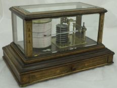 A barograph in five-sided glazed display case with retailer's label "Ollivant & Botsford of
