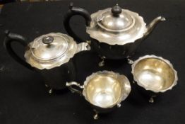 An early 20th Century silver four piece tea service to comprise teapot with ebony finial and handle