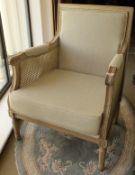 A pair of modern arm chairs with bergère sides and upholstered backs and seats,