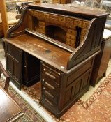 An early 20th Century oak roll top desk with fitted interior together with a oak Captain's style