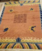 A Chinese carpet, the central panel set with Chinese symbols on a salmon pink ground,