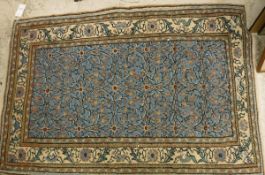 A Persian rug, the central panel set with all over floral decoration on a light blue ground,