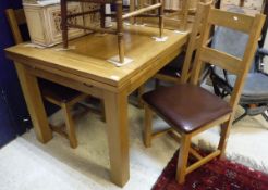 A modern oak drawer leaf dining table with a set of six similar chairs with leather seats