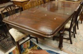 A reproduction mahogany extending dining table in the Victorian manner on four turned and reeded