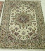 A Persian carpet, the central panel set with a stylised floral medallion on a cream ground,