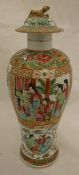 A Cantonese famille-rose decorated lidded vase with panels set with figures in an interior