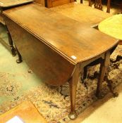 A George III mahogany oval drop-leaf dining table on turned tapering legs to heavy pad feet