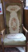An early 20th Century oak framed high back carver chair with needlework upholstered seat and