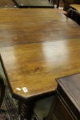 A Victorian walnut dining table on turned, ringed and fluted supports,
