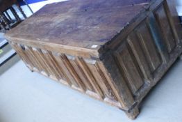 A Continental pine coffer with hinged lid abovew eight panels raised on stile supports