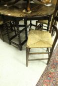 An oak drop-leaf dining table on bobbin supports,