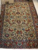 A Kashan rug, the central panel set with all over floral decoration on a cream ground,