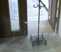 A cast iron stand and a curved glass fire screen