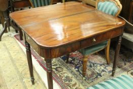 A Victorian mahogany fold-over tea table with single frieze drawer on turned and ringed tapering