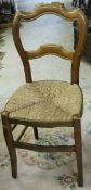 A set of six Continental fruitwood dining chairs with shaped backs and rush seats