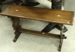 A modern oak dining table raised on cup and cover supports to stretcher base,