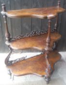 A Victorian walnut three tier whatnot on moulded and turned supports to turned cup and cover feet