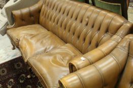 A modern leather three piece suite with button back upholstery to the scroll arms,