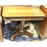 A Victorian rosewood fold-over card table on centre pedestal to quatrefoil base,