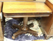 A Victorian rosewood fold-over card table on centre pedestal to quatrefoil base,