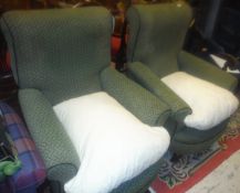 A pair of Victorian armchairs with curved front seats raised on ringed and turned front legs to