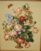 A modern framed needlework depicting a vase of flowers and butterfly,