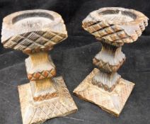 A pair of carved and stained pine candle holders