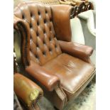 A pair of Georgian style brown leather wing back armchairs with cabriole front legs